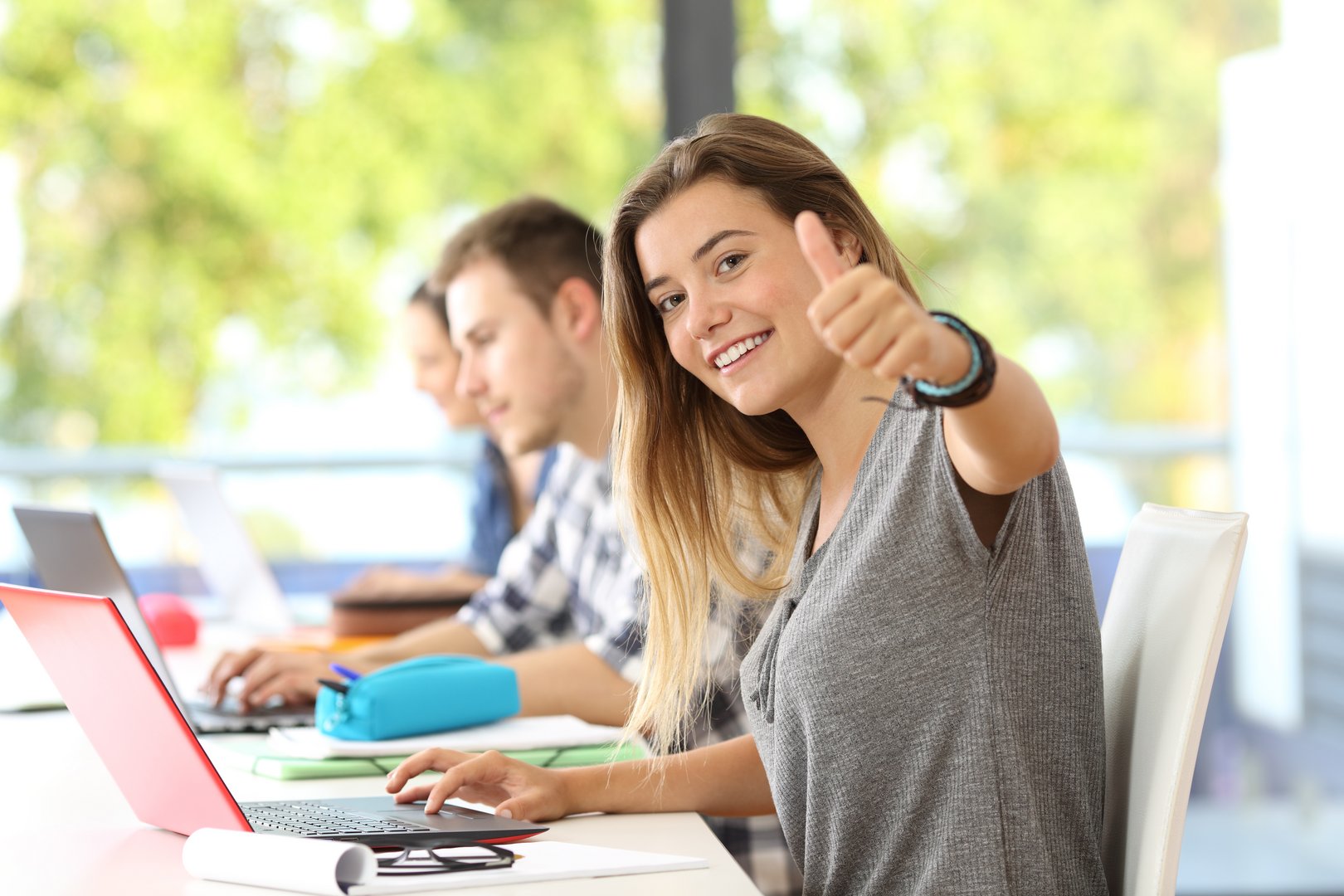 Happy student with thumbs up in a classroom Wymiana i mobilność
