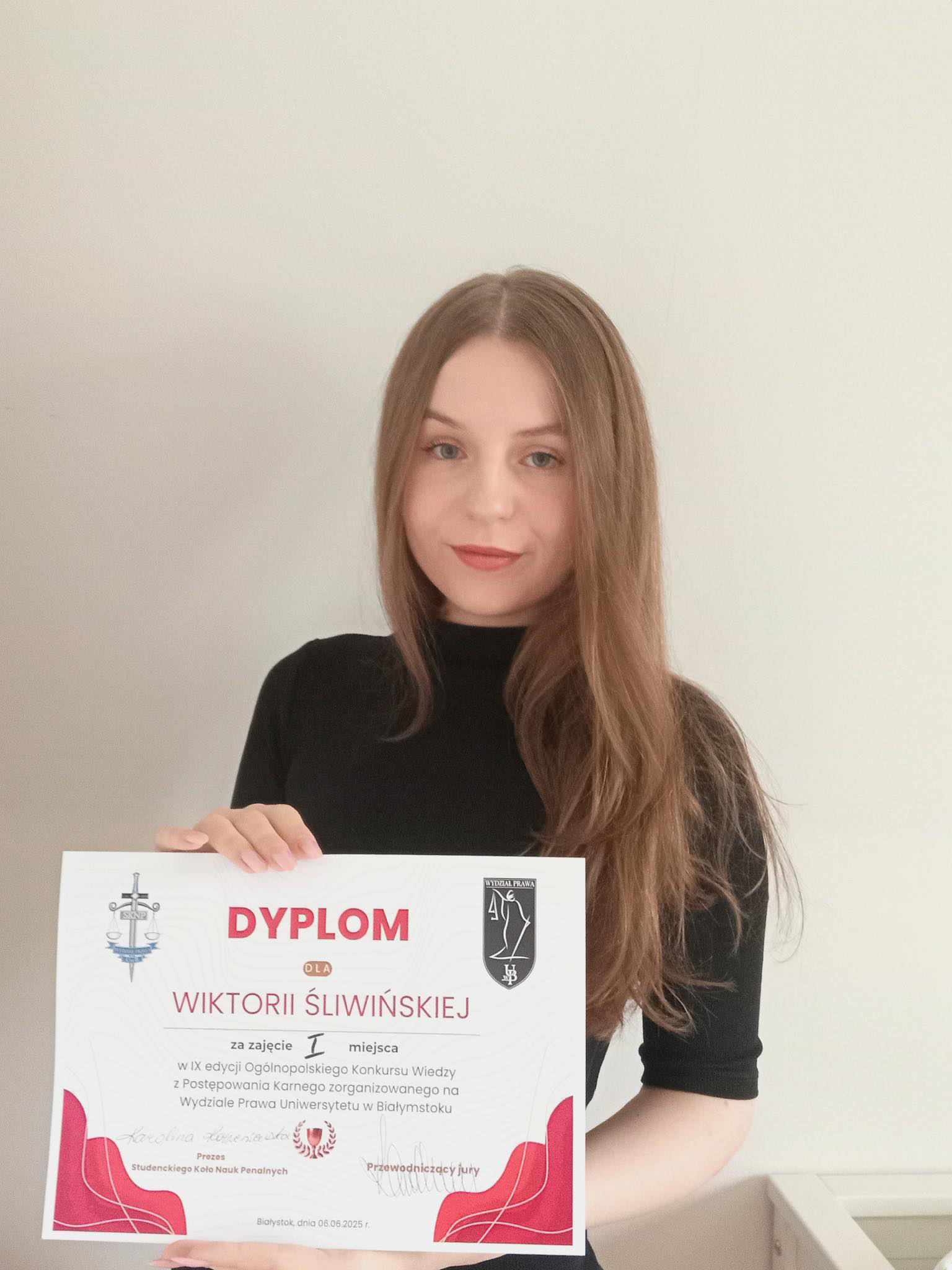 The winner holding the diploma