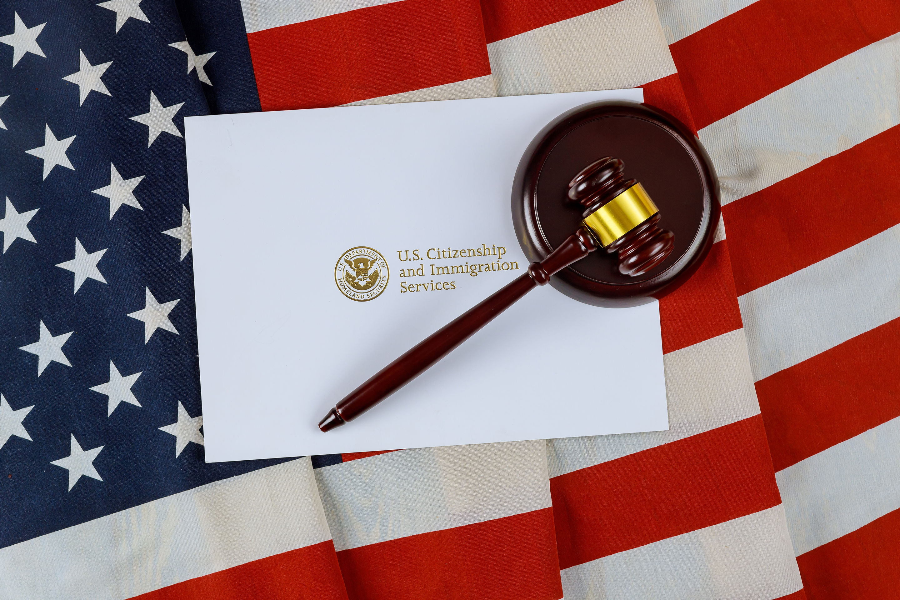 A white envelope and a judge's gavel against the background of the American flag