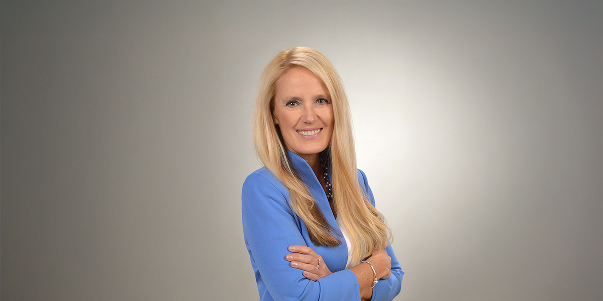 Kobieta długich blond włosach w niebieskim żakiecie