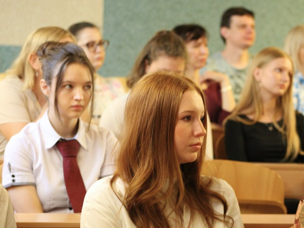 Na zdjęciu widać grupę młodych ludzi siedzących w sali wykładowej