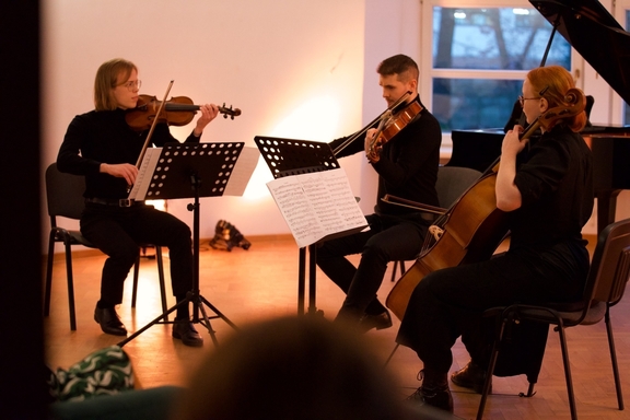 Three members of the Lumiére ensemble playing string instruments