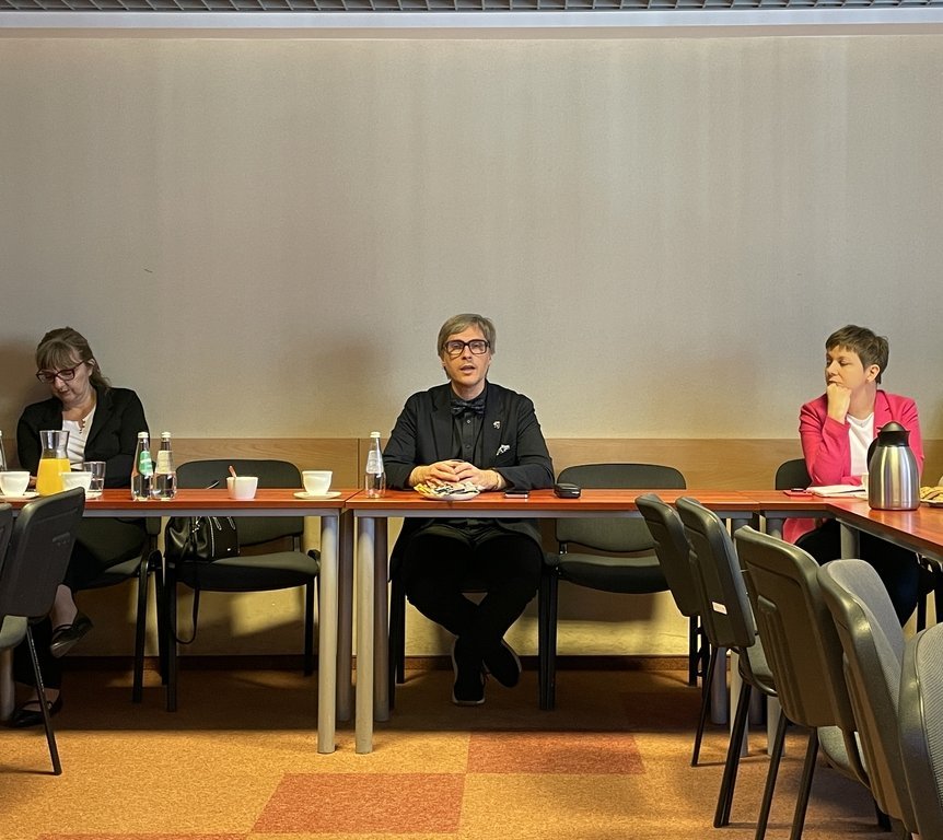 a group of people sitting at tables with refreshments