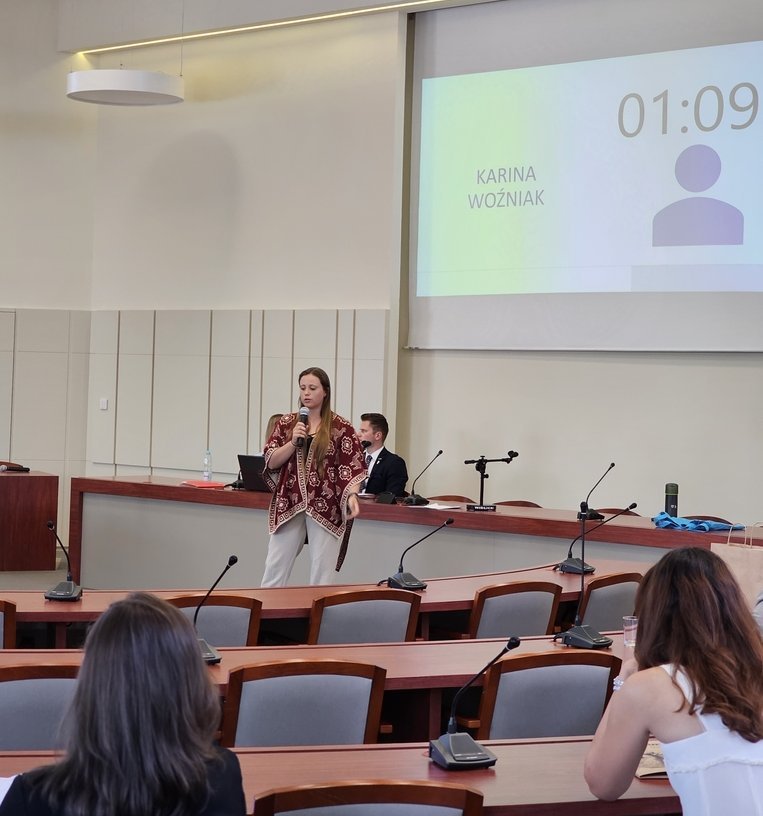 Karina Woźniak w sali wykładowej stoi przed publicznością