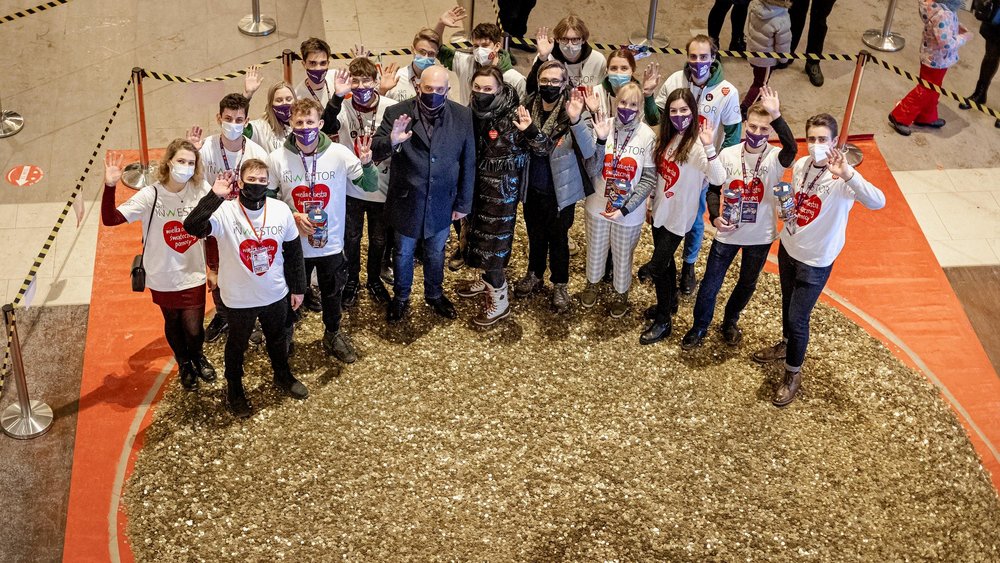 Students from the Student Science Club Inwestor with the UL Authorities are standing next to a heart made of gold coins