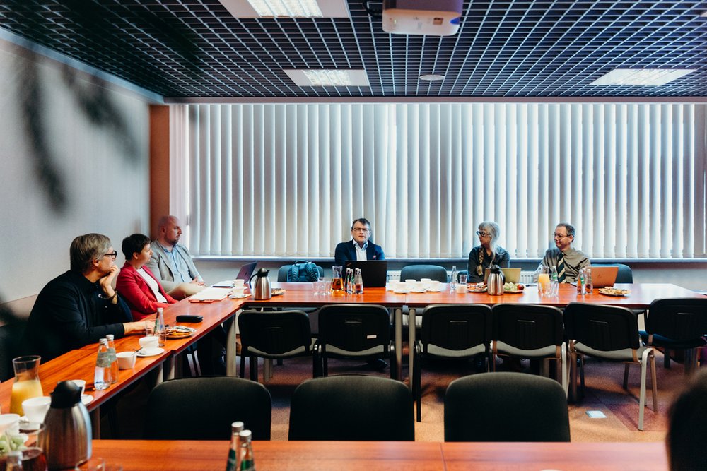 a group of people sitting at tables with refreshments