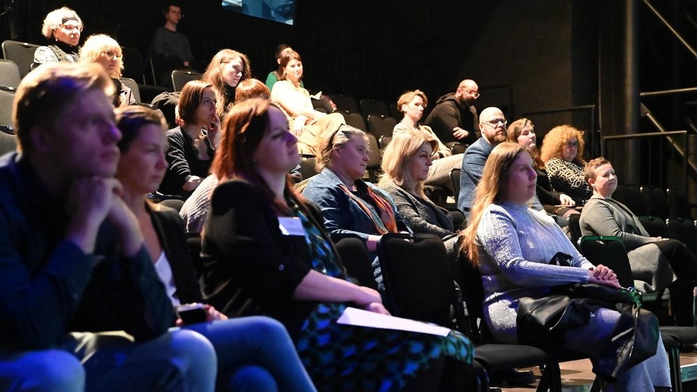 a dozen or so people are sitting in the audience