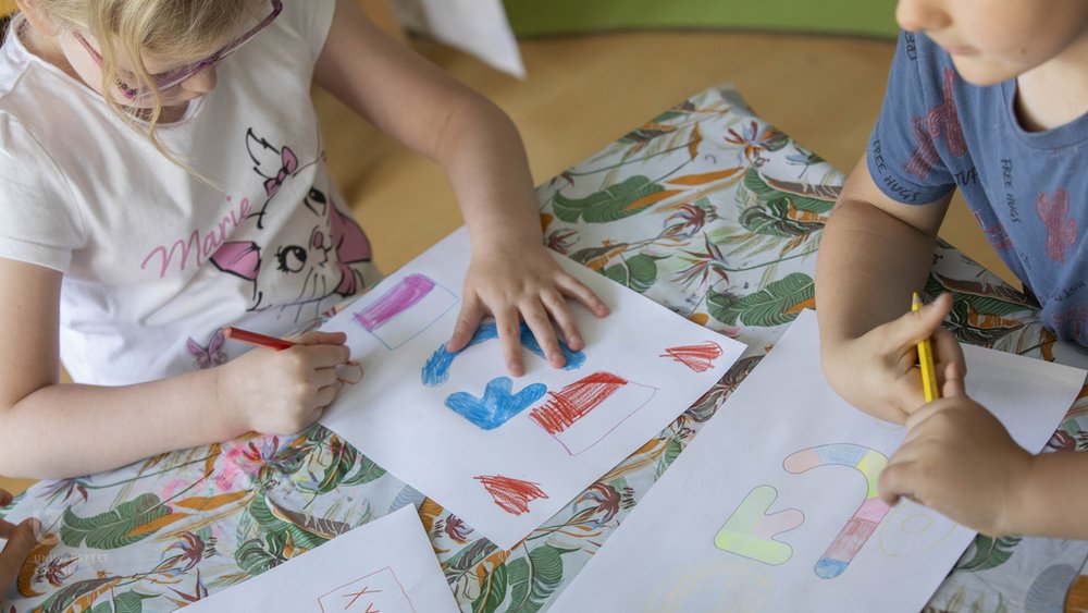 Children painting card designs for the University of Lodz campaign "Flowers? - No, thank you?"