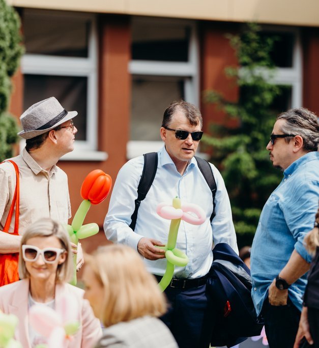 a group of people holding balloon flowers
