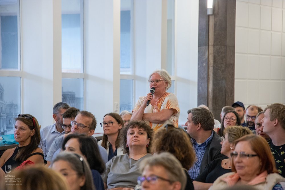A woman from the audience asks a question through the microphone