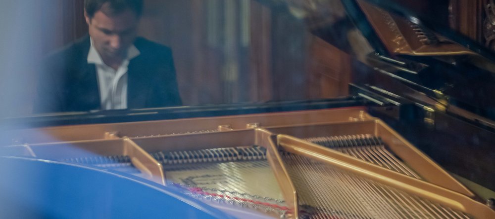 A man in a suit playing the piano