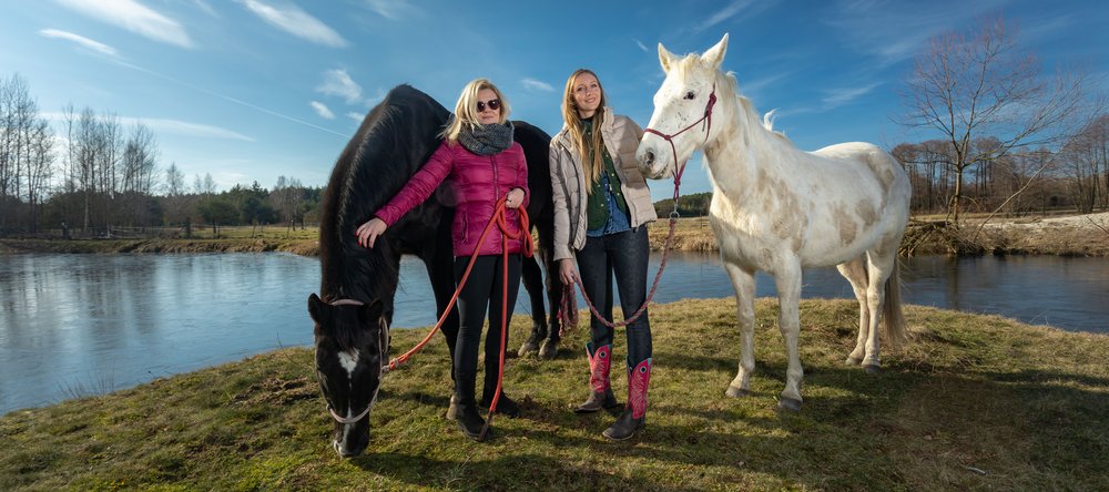 [Translate to English:] zdjęcie przedstawiające Kingę Rucką i Monikę Talarowską pozujące z dwoma koniami