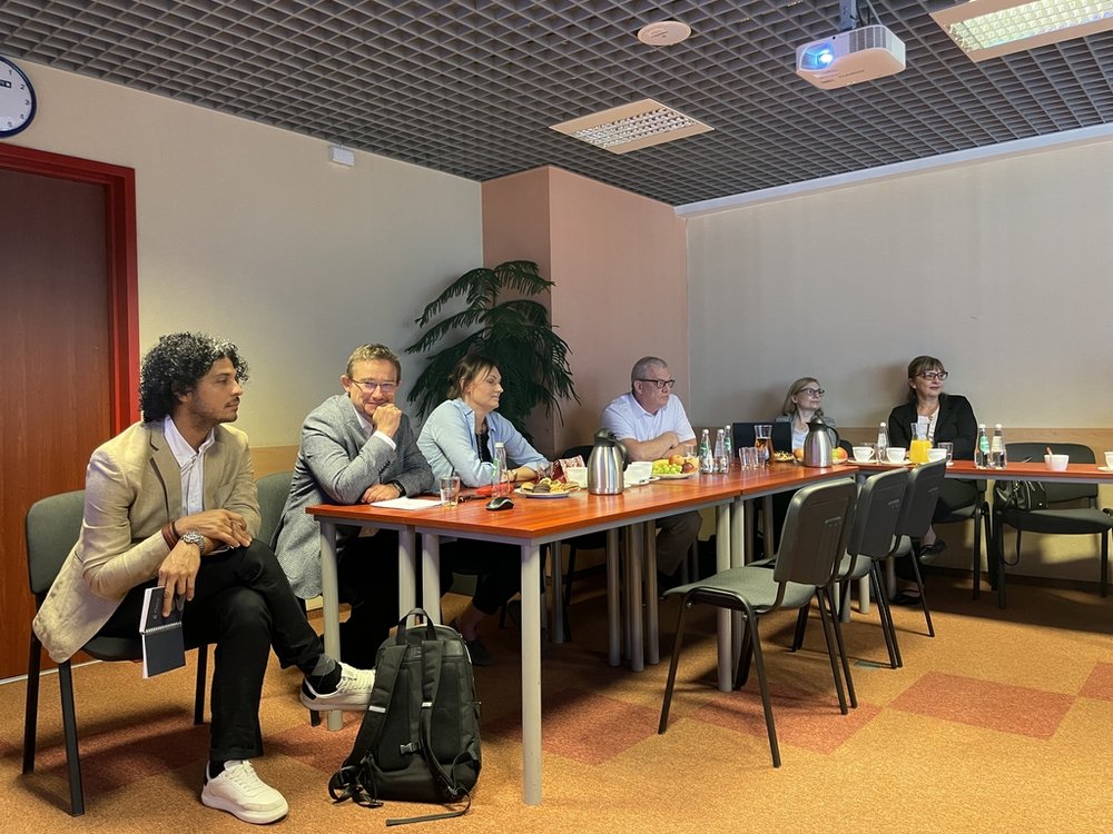 a group of people sitting at tables with refreshments and laptops