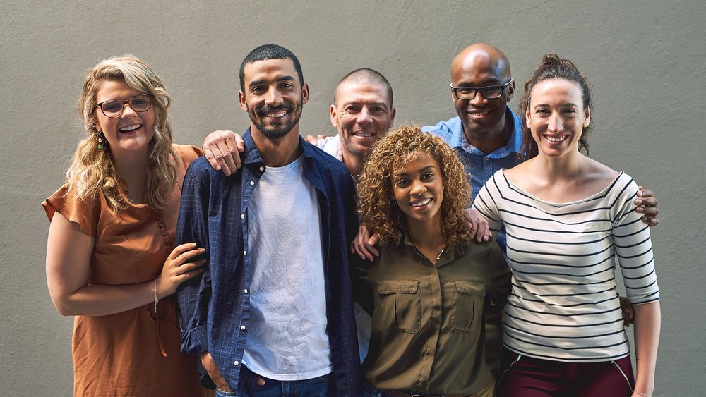 Shot of a group of cheerful friends standing together for a portrait while looking at the camera