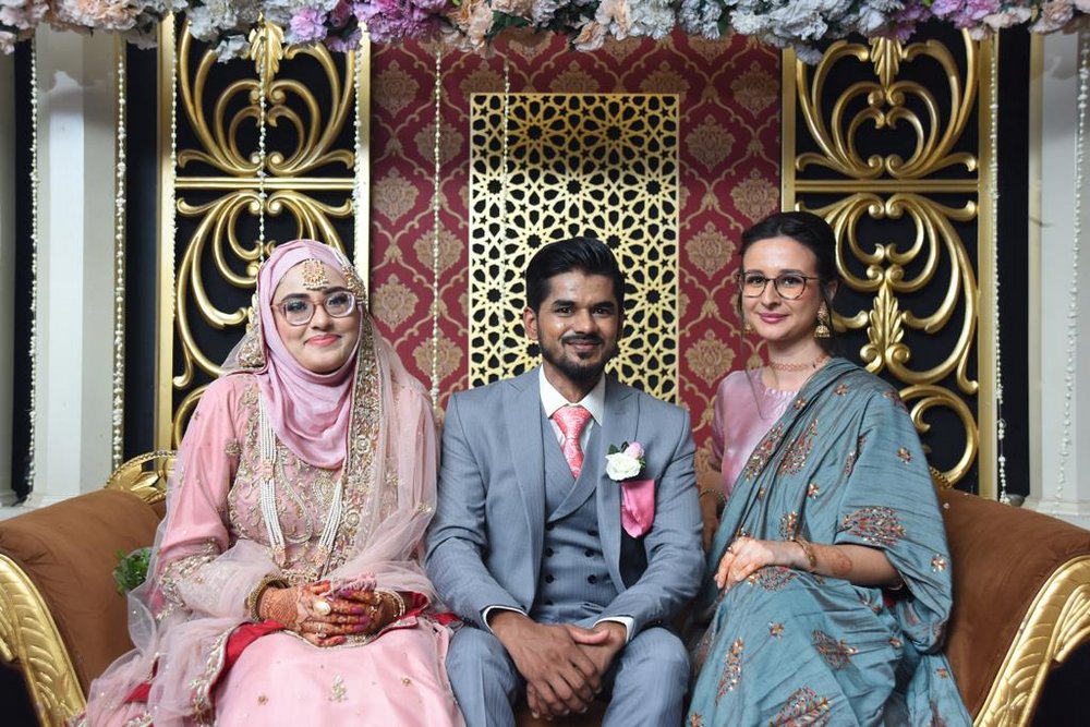 The student with the newly-weds during a wedding in Pakistan