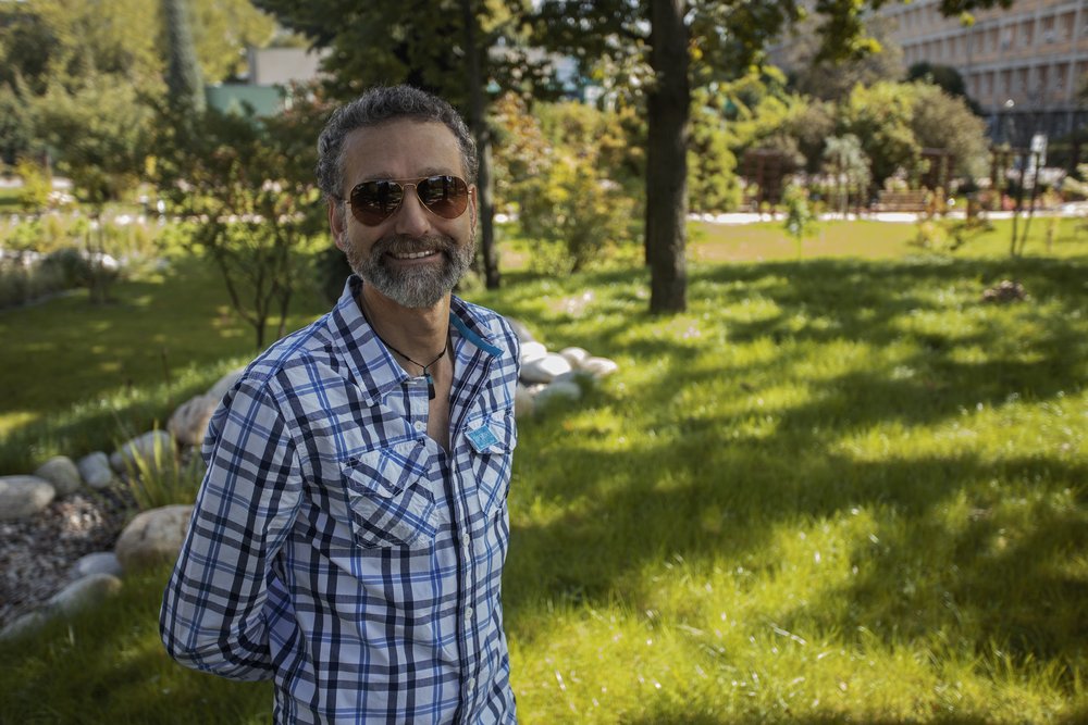 uśmiechnięty profesor Kok w okularach przeciwsłonecznych na tle wydziału