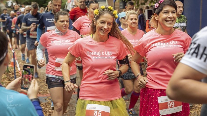 A group of people run through the forest in a sports competition