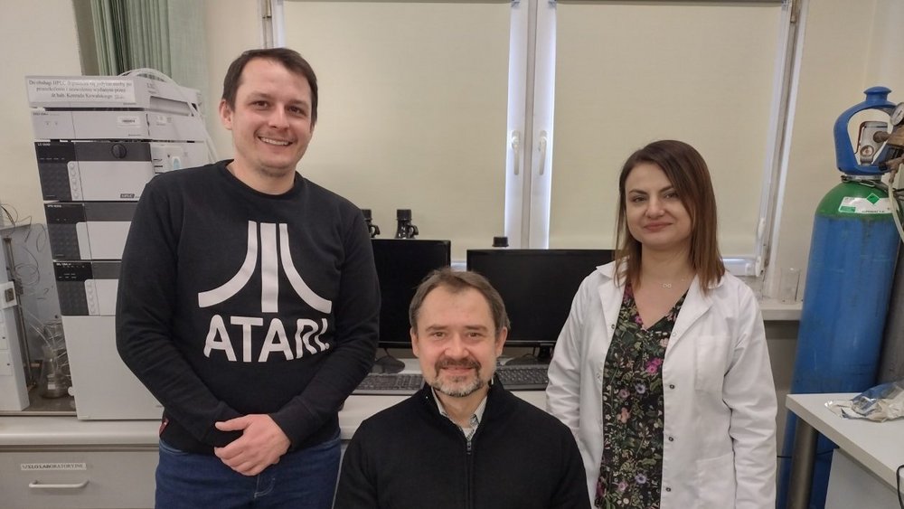 Silhouettes of a woman and two men. Prof. Konrad Kowalski (in the centre) with his colleagues - dr Joanna Skiba and dr Lukasz Szczupak.