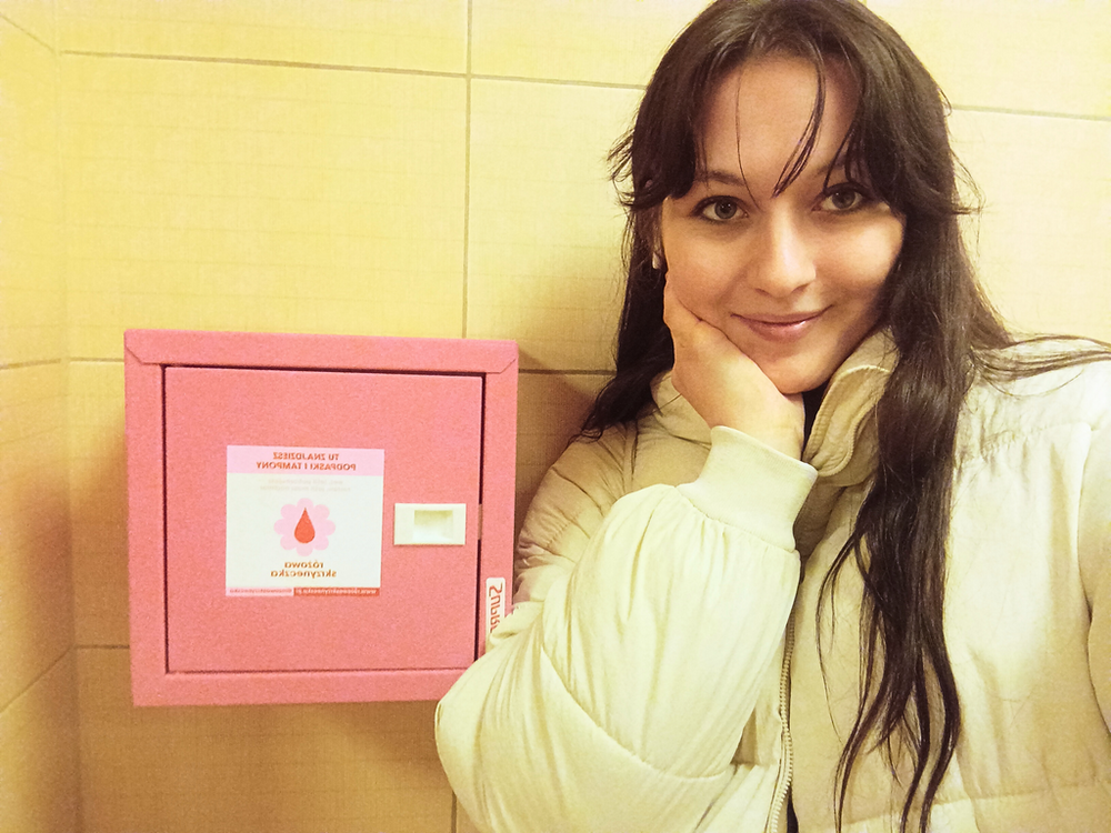 a female student standing next to the pink box