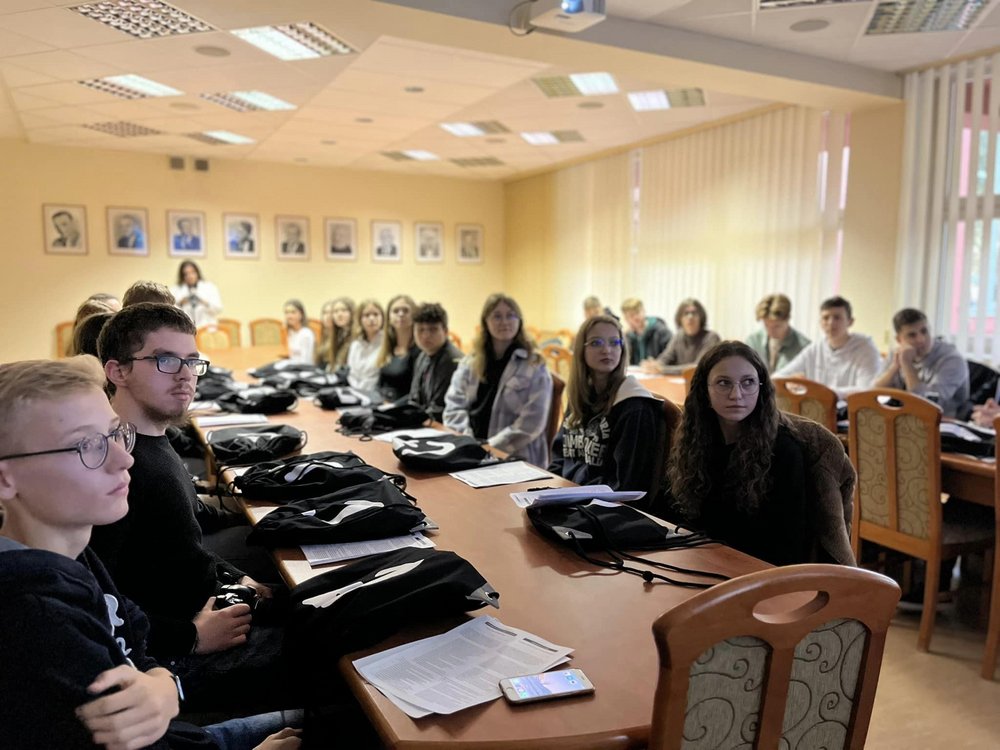 zdjęcie przedstawia grupę młodych ludzi, nastolatków, w sali wykładowej 