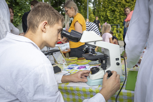Student pochyla się nad okularem mikroskopu. Student pochyla się nad okularem mikroskopu.