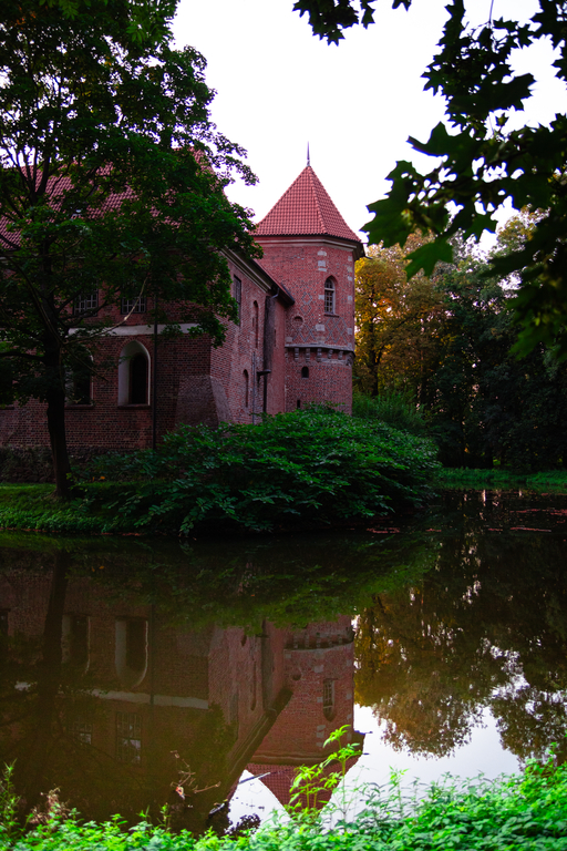 widok wieży zamku w Oporowie oraz fosa z wodą