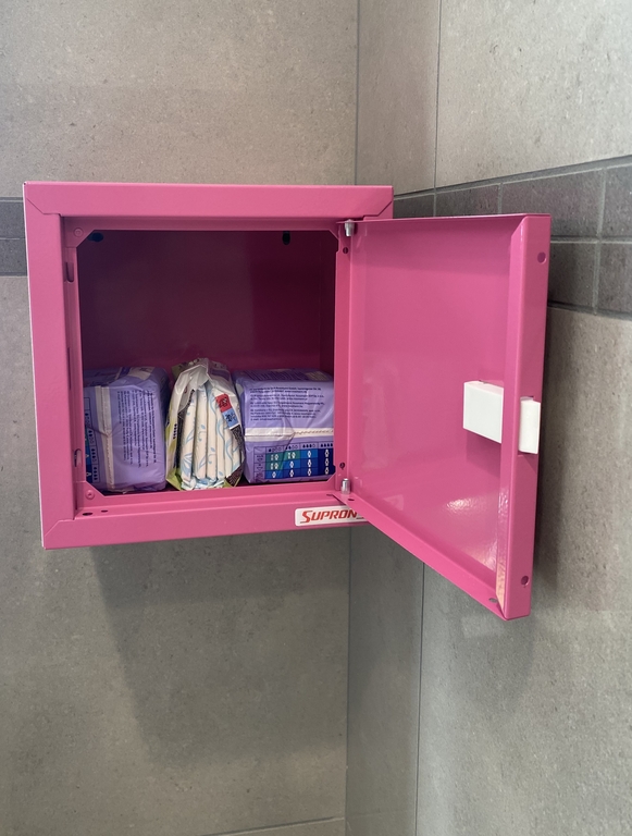 różowa skrzyneczki z paczkami środków higieny osobiste w środku